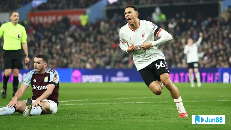 Cầu thủ Liverpool với áo đỏ chạy với bóng trước cầu thủ Aston Villa trong trận đấu